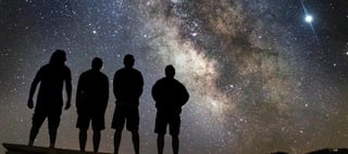 Silhouettes against starry night sky