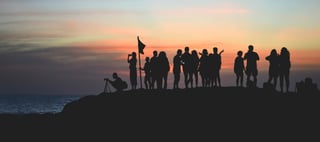 People standing on cliff at sunrise